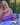 Smiling lady enjoys High Tea with Wild Blackberry and Manuka Honey in a garden setting.