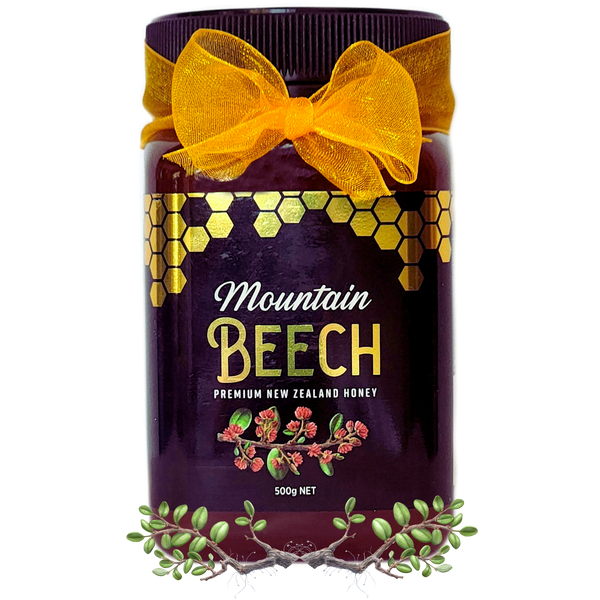 Mountain Beech Honey jar with a shiny black label and bright yellow ribbon sparkling gold in the light.